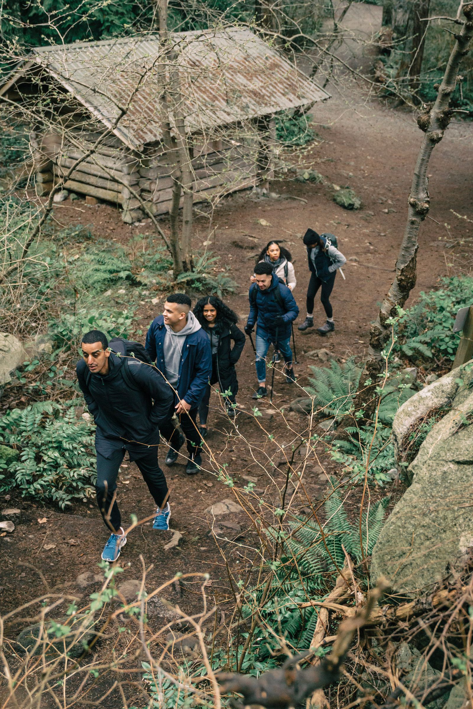 A group actively hiking uphill along a wooded trail